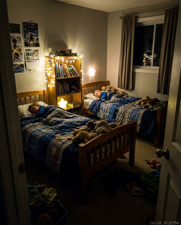 Twin boys asleep in their own beds