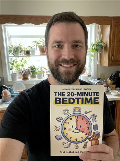 Dad in his kitchen holding Book 2